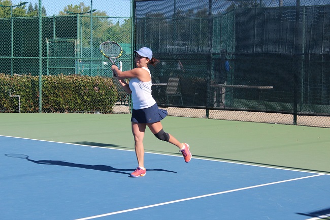 Playing tennis in court.