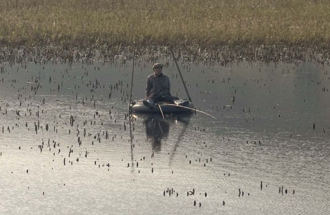 There is a lake on the way to Wonsan where fishermen use tires as a mode of transport for fishing